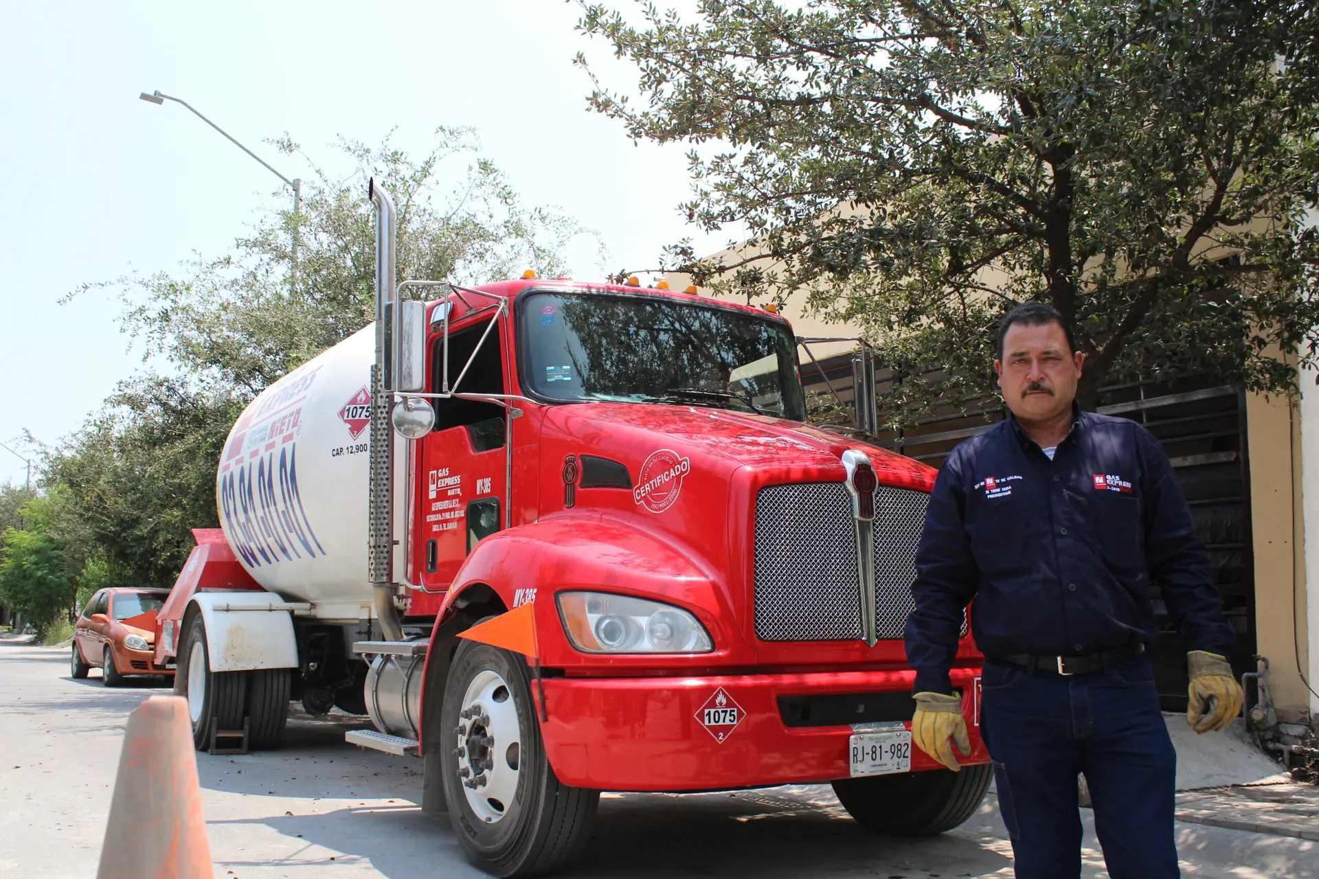 Operador de Gas Express Nieto junto a una pipa roja de gas LP